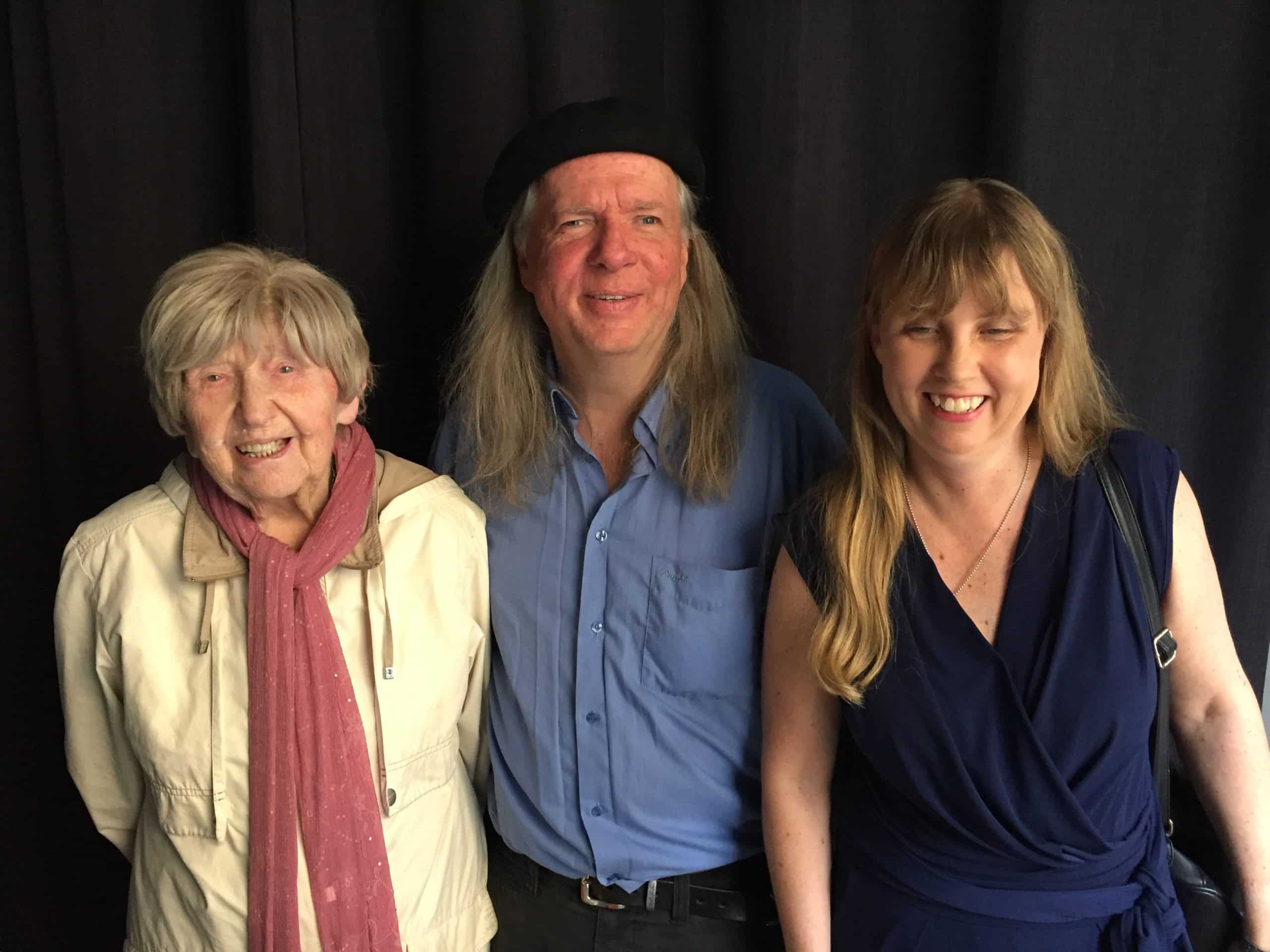 Gruppbild med Dagny, Ulf och Anna i studion med svart bakgrund. Dagny har kort grått hår, en ljusrödrösa scarf och en ljusbeige jacka. Ulf har en svart basker, långt grått hår och en mellammörkblå skjorta. Anna har långt blont hår med lugg framtill och en mörkblå v-ringad klänning utan ärmar.