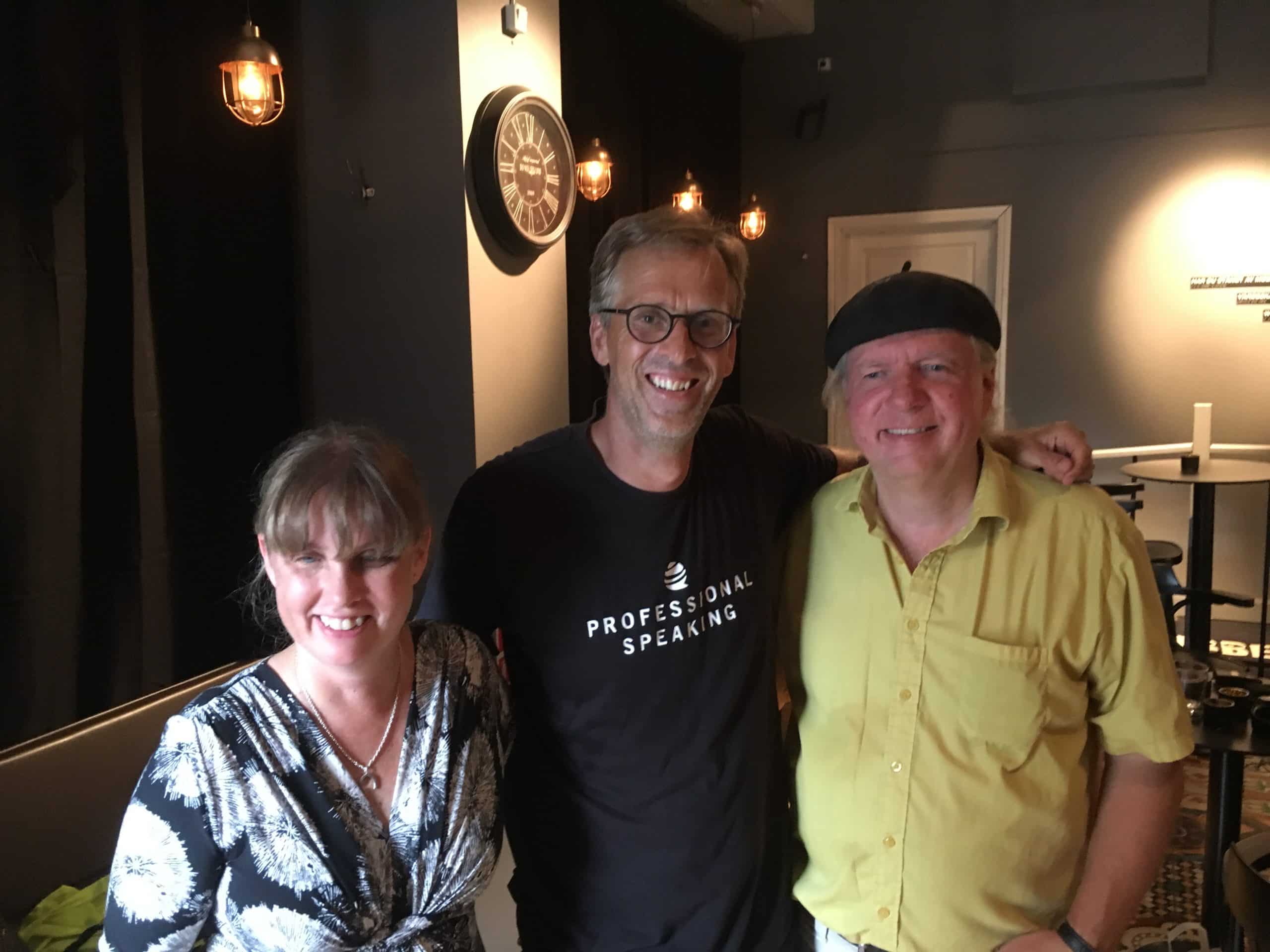 Anna, Fredrik och Ulf i studion. Anna har ljust hår med lugg och har på sig en klänning som är svart och vitmönstrat samt ett silverhalsband. Fredrik har kort ljust hår, glasögon samt en svart tröja med texten Professional Speaking. Ulf har grått hår och bär en svart basker samt en gul skjorta.