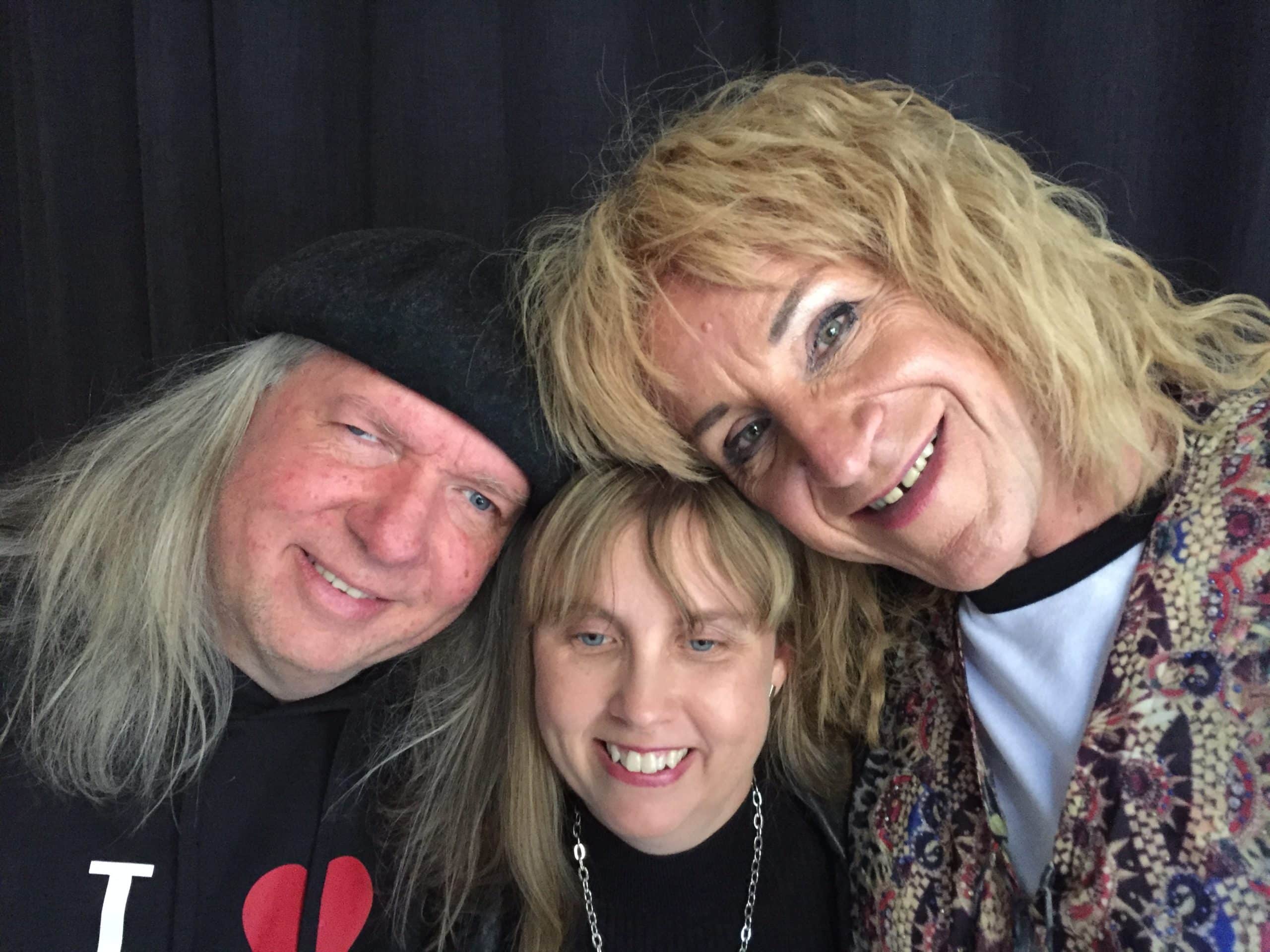 Närbild på Ulf Nordquist, Anna Bergholtz och Claes Schmidt Sara Lund. Ulf har på sig en svart basker, grått långt hår och en svart tröja. Anna har långt blont hår med lugg framtill, svart klädsel på överkroppen och en silverkedja. Claes Schmidt Sara Lund har blont långt lockigt hår, vit tröja under en spetsigt mönstrad klädsel ovanpå.